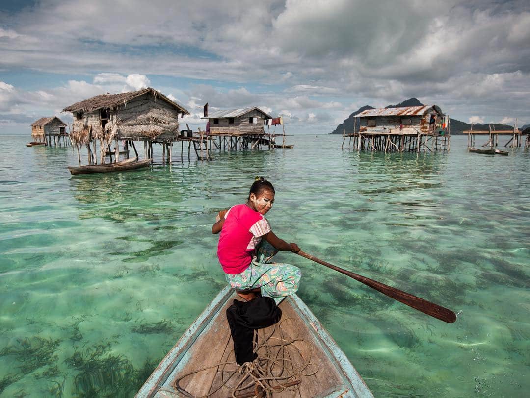 のインスタグラム：「Photo by @paleyphoto | A young girl paddles out to visit friends with her face dusted in bedak sejuk, a cooling powder made of rice and pandan leaves. #Malaysia #Island」