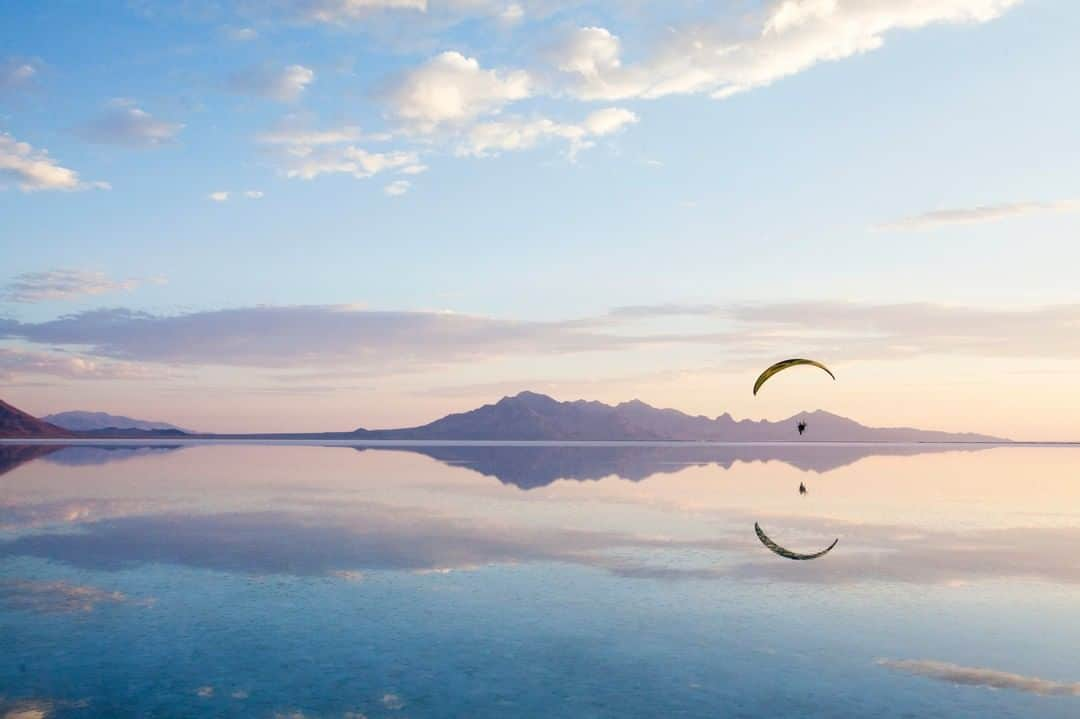 National Geographic Travelさんのインスタグラム写真 - (National Geographic TravelInstagram)「Photo by @sofia_jaramillo5 | Athlete @nicgreece paramotors over the Bonneville Salt Flats in Utah. This was a unique morning as rain from the night before flooded the flats and created breathtaking reflections in the water. The flats formed when ancient Lake Bonneville dried up years ago. As water evaporated, salt deposits were left. During the last Ice Age, about 15,000 years ago, Lake Bonneville's size was equivalent to the size of Lake Michigan. It expanded across one-third of present day Utah and into parts of neighboring states.  #fly #utah #saltflats」3月20日 22時02分 - natgeotravel