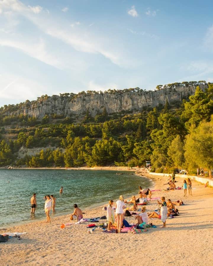 National Geographic Travelさんのインスタグラム写真 - (National Geographic TravelInstagram)「Photo by @emilypolar | Locals and tourists alike enjoying a rare soft patch of sand west of Split. The rock band above houses an old abandon church and surprisingly good rock climbing. To see more of this world in warm light follow @emilypolar #Croatia #Split #KasjuniBeach」3月22日 9時57分 - natgeotravel