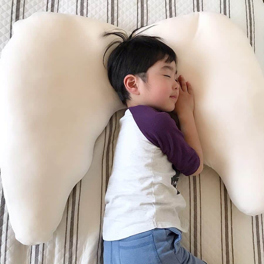 のインスタグラム：「眠育アイテム😪 . . 西川の子供向けの枕ブランド 【Suu Goo】のエンジェルまくら❤︎ @min_ikupj . . 寝相が悪く、寝返りをよくする息子👦🏻 でもツバサ部分に抱きついてくれるから、 枕がズレにくくて、 隣で寝てる私も主人も前よりグッスリ眠れる😂💕 . . 両面別素材の2way仕様だから、 好みの方を使えるよ😊 しかも、4色もあるんです♡ カバーは取り外して、洗濯可能なのも嬉しい！ . . 寝ていると、 まるで天使のはねが生えたみたいで、 とっても可愛い😍 しかも、背負えるパッケージに入っていたから、 せっかくなので背負って撮ってみました♡ 可愛い…❤️❤️ . . こんな可愛くて使える天使の羽まくら プレゼントにもオススメですよ🙆‍♀️ . . . #min_ikupj #眠育 #SuuGoo #エンジェルまくら #西川 #ねむりと未来プロジェクト #まくら #写真映え #ギフト #寝具 #はじめよう眠育 #キッズまくら #こどもの眠り #キッズ #プレゼント  #天使の羽 #インスタ映え #男の子ママ #キッズコーデ #男の子コーデ #子どものいる暮らし #mamagirl #locari #kids_japan #コドモノ #ママリ #ママガール #シンプルな暮らし #育児 #子育て」