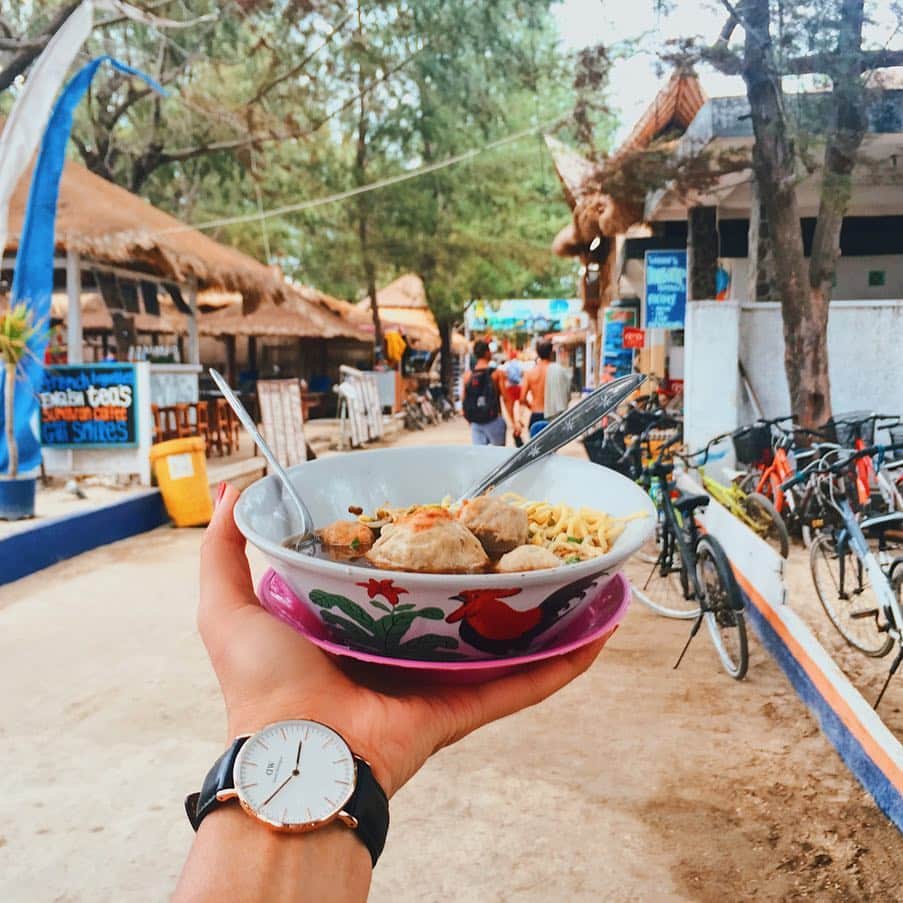 Girleatworldさんのインスタグラム写真 - (GirleatworldInstagram)「Hi everyone!!! I'm back with a little... 4 year challenge. I managed to find the same Bakso push cart in Gili Trawangan that @singasongjess and I visited 4 years ago! I swear it wasn't planned - I was just biking down the road, spotted a bakso cart and of course I had to stop. It was only after taking the photo and comparing it with the one I took 4 years ago that I realized I was actually standing at the same spot! He was still charging the same amount per bowl. The island has changed quite a bit though. The first image was taken in 2019 and the second image is the one I took in 2015. Swipe right/left and spot the difference.  What is Bakso? Ask any Indonesian about Bakso and i'm sure you would be met with excitement. It's a small bowl of yellow noodles, meatballs and fresh beansprouts in clear beef broth, served with fried shallots, chili and kecap (sweet soy sauce). Bakso is traditionally sold on the street in a small push cart (called "gerobak" in Indonesian) that would go around the neighborhood during supper time and you have to catch the bakso guy at the right time. Because of its small portion, we normally eat it as snacks for supper or midday between meals. Nowadays you can also get them at restaurants for a meal-sized bowl. We got this off a push cart in Gili for less than $2 and proceeded to eat it on the side of the street.  #shotoniphone #iphonexsmax #giliislands #gili #lombok #lombokisland #beach #gilitrawangan #visitlombok #explorelombok #girleatworld #indonesia #bakso」3月26日 9時22分 - girleatworld