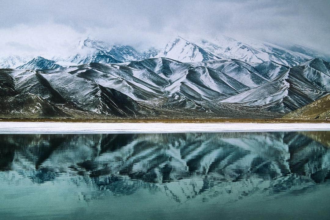 Michael Yamashitaさんのインスタグラム写真 - (Michael YamashitaInstagram)「The Pamir Mountains cast a perfect reflection in the crystal clear waters of Karakuli Lake, Xinjiang, China.  #PamirMountains #Karakul #KarakoramHighway #thenatureconservancy @tnc_hk」3月27日 0時04分 - yamashitaphoto