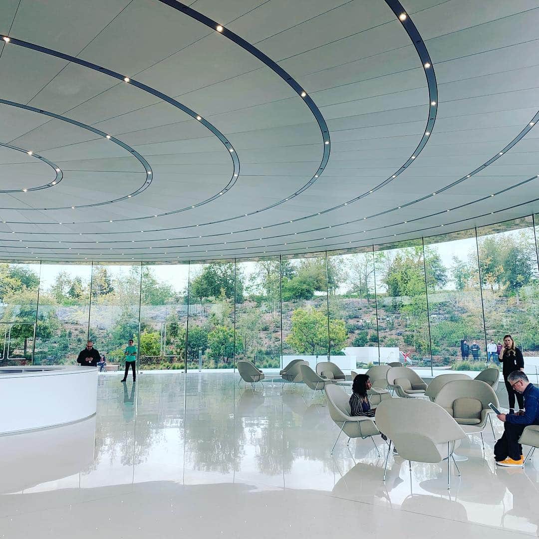 林信行のインスタグラム：「I wonder if these furnitures would remain here; it is a nice setting but I kind of like the beauty found in the emptiness. いつもは瞑想空間のようにまったく何も置かれてないスティーブ・ジョブズシアター。今回はファニチャーが置かれていた。雨だからの配慮かと思ったけれど中央に置かれた円形のバーカウンターは常設の雰囲気も… あの何もない空間は、それはそれで良かったんだけどなぁ…」
