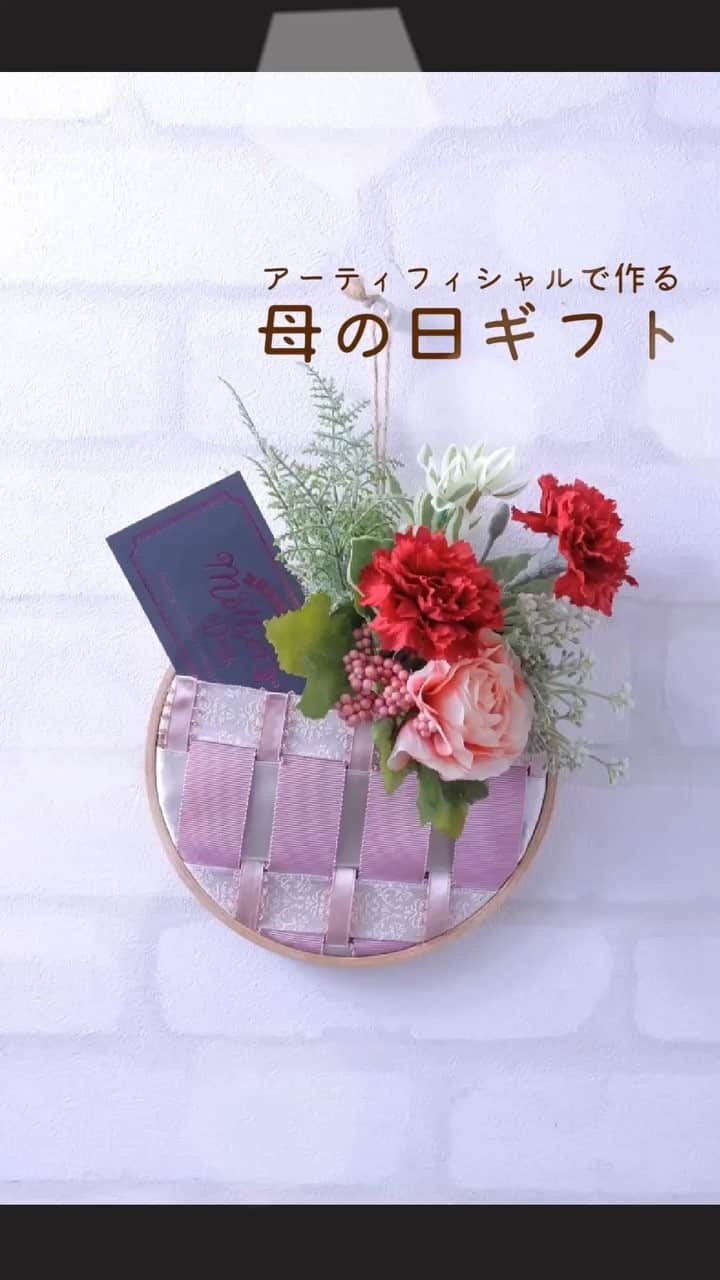 東京堂アーティフィシャルフラワーMAGIQのインスタグラム：「【アーティフィシャルで季節を迎える】 〜Spring greeting(スプリンググリーティング)〜 ・ ‪アー‬ティフィシャルで作る 💐母の日ギフト💐 ・ ‪🎀リボンを編み込んでカレイドに挟み、ポケットを作ります。‬ ‪おうちに余っているリボンでも作ることができます。‬ ‪カーネーションとグリーティングカードを添えて、‬ ‪母の日プレゼントとしていかがですか？‬ ‪中身を変えればいろんな場面で使えます。‬ ・ ・ ・ ‪<使用材料>‬ ・ FS600331 カレイドフレーム 15.5cm RM160009  40 ピコットサテンリボン9mm RM890025  40 グログランリボン25mm RA3062  19 ブリクソン25mm RT37127  44 S.U.ノーブルサテン40mm RT75802  66 ラフリネン FM9063  3 パリスカーネーションピック FM6025  6 ロレッタラナンピック FM7312  42 パルマベリーピック FG9347 ユーホルビアグラスブーケ ZSMG821 母の日ギフトカード AW72070 コイルワイヤー2  200m ・ ・ ・ 【You Tube TOKYODO公式チャンネル】 見て学べて役立つ、お花に関する動画満載❗️ 👇👇👇 https://m.youtube.com/channel/UCyD95_Gb0wQhvTRm9FDJnsQ ✳️【チャンネル登録】お願いします🙇‍♀️ Please subscribe to my channel ❗️ 请注册 ❗️ 채널 등록 고마워요 😁 ・ #TOKYODO#MAGIQ#MAGIQのある暮らし#東京堂#アーティフィシャルフラワー#アーティフィシャル#アートフラワー#造花#花のある暮らし#花のある生活 #花好きな人と繋がりたい#フラワーデザイン#フラワーアレンジメント#フラワーアレンジ#アレンジメント#リボンアレンジメント#母の日プレゼント#リボン#母の日#カレイドフレーム#カーネーション#artificial#artificialflower#花藝#插花#花藝課#保鮮花#不凋花#꽃스타그램」
