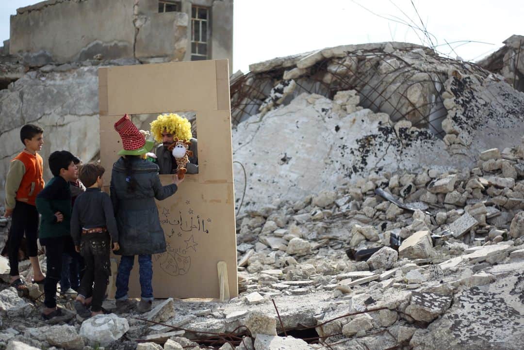 AFP通信さんのインスタグラム写真 - (AFP通信Instagram)「AFP Photo 📷 @amer.alhamwe - Children watch a puppet show performed by a Syrian actor, through a makeshift puppet theatre set up among the rubble of collapsed buildings in the town of Saraqib in the rebel-held northern Idlib province, on March 27, 2019.」3月28日 2時04分 - afpphoto
