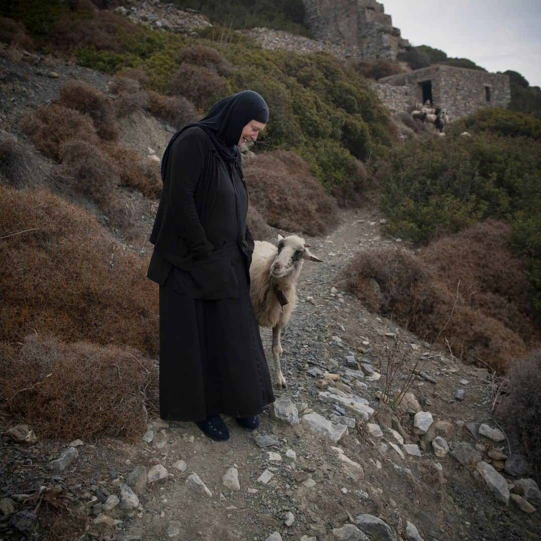 National Geographic Travelさんのインスタグラム写真 - (National Geographic TravelInstagram)「Photo by @chiaragoia | Sister Irini talks to a sheep near St. George Valsamitis monastery where she lives on the island of Amorgos, in Greece. Sister Irini is a Greek Orthodox nun who came to Amorgos for the first time 35 years ago as a tourist with her children and her husband. She fell in love with the island and she returned here as a nun 7 years ago when she took over an abandoned monastery and restored it herself. She spends her days gardening, painting, and praying, but always welcomes visitors to her monastery. #greece #amorgos」3月28日 10時04分 - natgeotravel