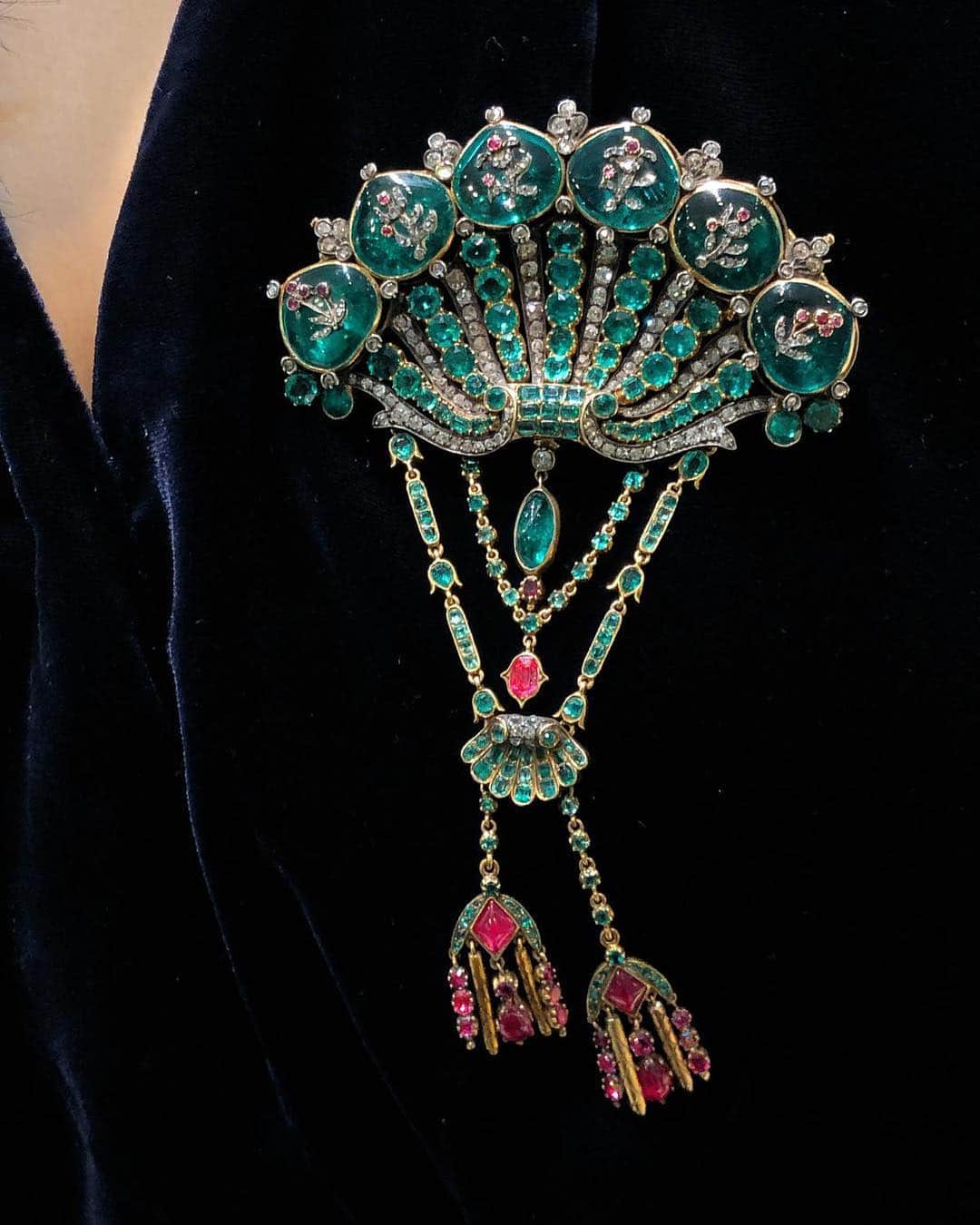 サザビーズさんのインスタグラム写真 - (サザビーズInstagram)「Cherished and treasured throughout the ages, this stunning 18th century Spanish royal emerald brooch has survived for more than 250 years. The brooch takes the form of a shell encrusted with #diamonds, #emeralds and #rubies, embellished with sprays of flowers on the crowning emerald #cabochons – perfected with emerald drops, gold tassels and a smaller shell. In the past it would have been pinned to the corsage of a royal court dress, sparkling under candlelit at lavish banquets. The stunning jewel was once owned by Lady Anne Maud Rhys, 7th Duchess of Ciudad Rodrigo (1910-1998), descendant of the 1st Duke of Wellington. To be offered as part of our Magnificent Jewels & Jadeite sale on 2 April and currently on view at the #HongKong Convention and Exhibition Centre. Modeled by our very own HK Head of Sale @cristeltan on her lovely velvet dress! #sothebysjewels #rococo #royaljewellery #18thcentury」3月29日 13時34分 - sothebys