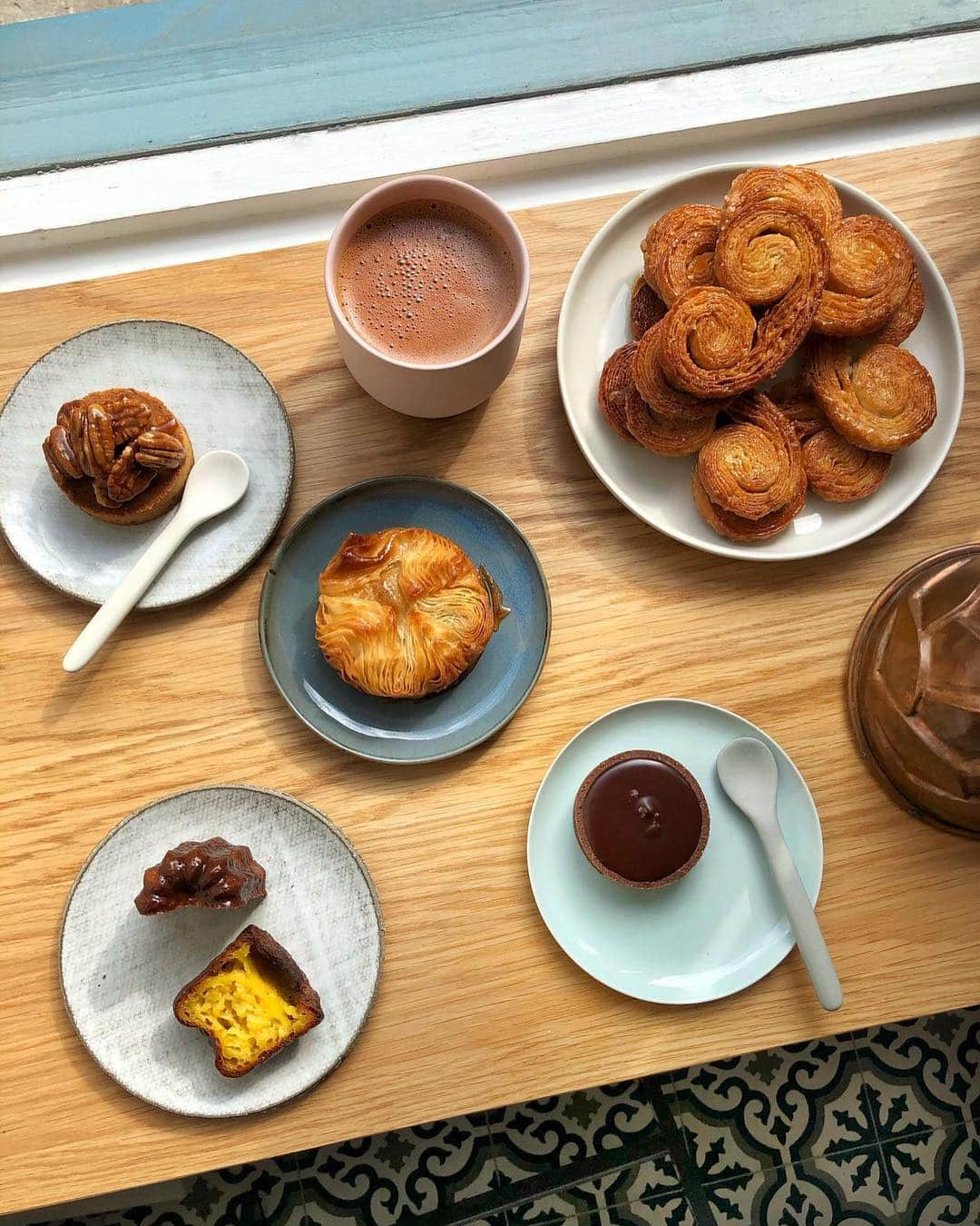 @LONDON | TAG #THISISLONDONさんのインスタグラム写真 - (@LONDON | TAG #THISISLONDONInstagram)「Morning! It’s @felicityspector here at the fabulous new @mielbakery in #WarrenStreet - tucking into an amazing spread by acclaimed pastry chef Shaheen Peerbhai aka @purplefoodie ... we’ve got a super flaky caramelised kouign amman, a sable Breton with pecans, a beautiful Valrhona chocolate tart and a crunchy, custardy canele warm from the oven. Plus a big cup of velvety hot chocolate... it doesn’t get much better than this! Shaheen is a total star - she trained in France at Le Cordon Bleu and Alain Ducasse with a James Beard Scholarship - somehow finding time to write a book, the Paris Picnic Club. Miel Bakery is her first solo place - get down there for the gorgeous pastries and cakes, as well as lunchtime focaccia and sourdough sandwiches - all of it baked on site, all of it totally delicious. 🧁❤️ // #thisislondon #london」3月29日 17時43分 - london