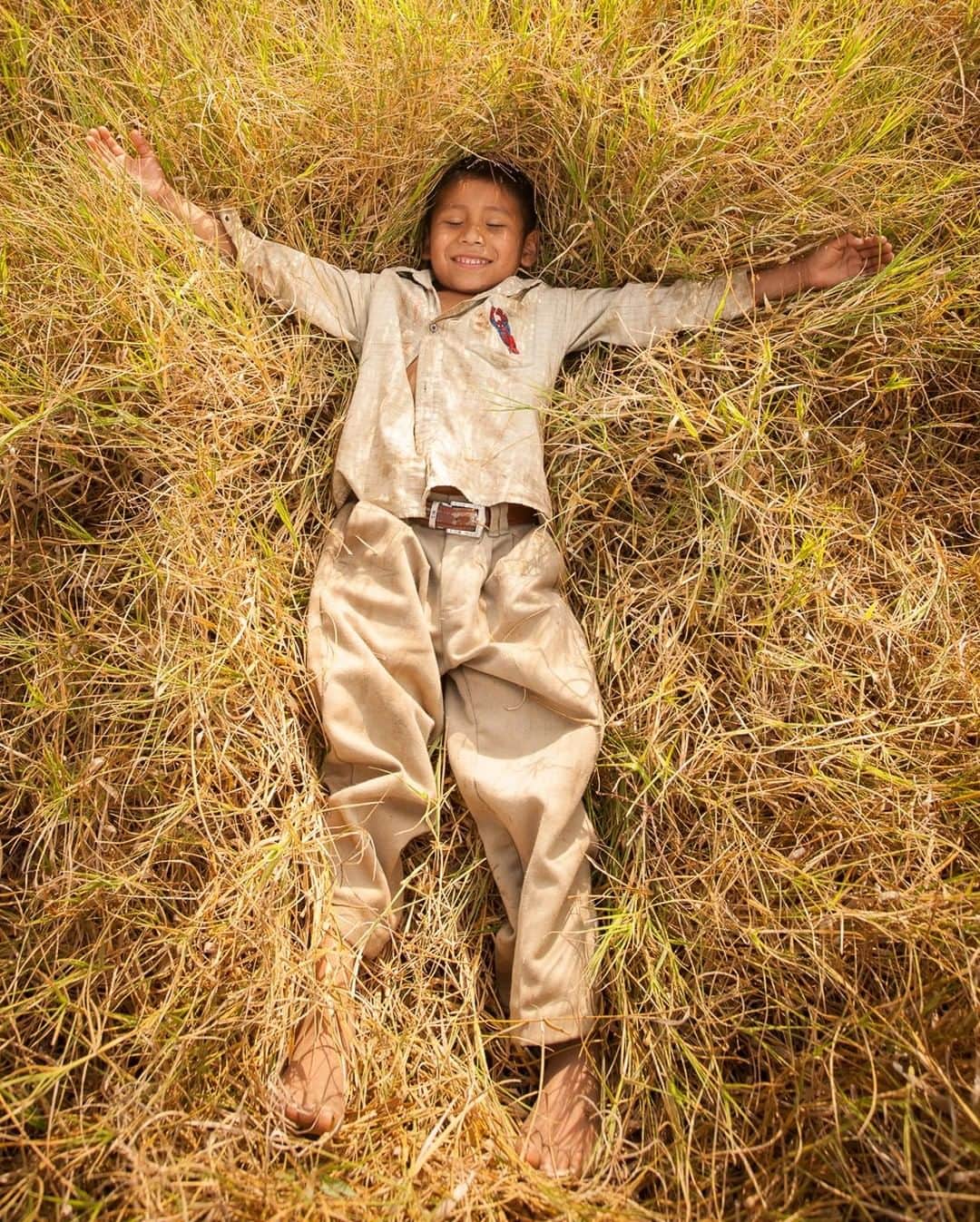 のインスタグラム：「Photo by @CristinaMittermeier | I wanted to make a portrait of this young boy but he was too shy, so instead of posing, he dropped backwards, laughing into the long grass in the El Triunfo Biosphere Reserve, in Chiapas, Mexico. I loved capturing this moment because he looked so content and at peace with the world. This boy lives in a Tzotzil Maya community, which makes up about one-third of the state’s indigenous population. They often do grueling work in coffee plantations and are the people who make our shade-grown, sustainable cups of coffee possible. #FollowMe at @CristinaMittermeier for more photos that celebrate #Gratitude from around the world. #Mexico #community #smile #Enoughness」