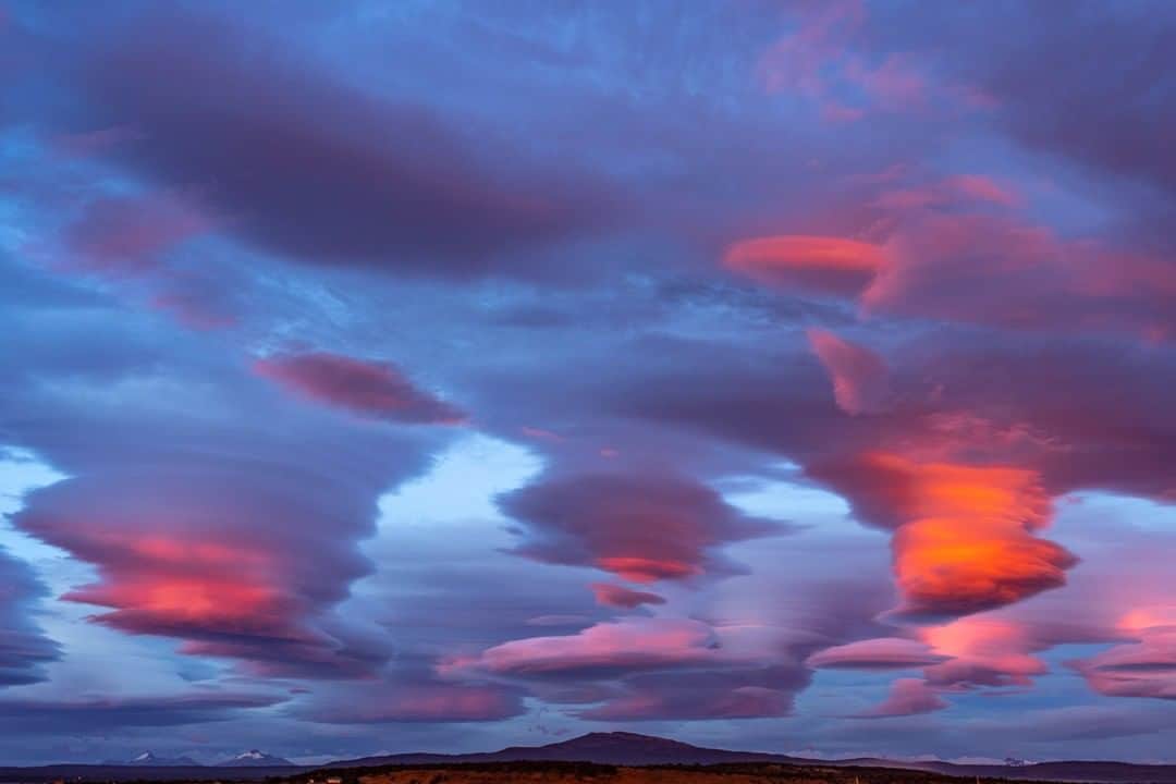 のインスタグラム：「Photo by Stephen Alvarez @salvarezphoto | Puerto Natales, Chile: After three glorious days in the Patagonian fjords, I awoke to this dramatic sunrise. Lenticular clouds like these are formed in the troposphere when rivers of air rise above a surface obstruction. The successive turbulence causes large standing waves of moist air to form striated clouds. They are often the harbinger of rain or snow to come. True to form, the rain started just 20 minutes after sunrise ended. Shot on assignment for @natgeotravel for more images like this from around the world follow me @salvarezphoto. #lenticular #patagonia」