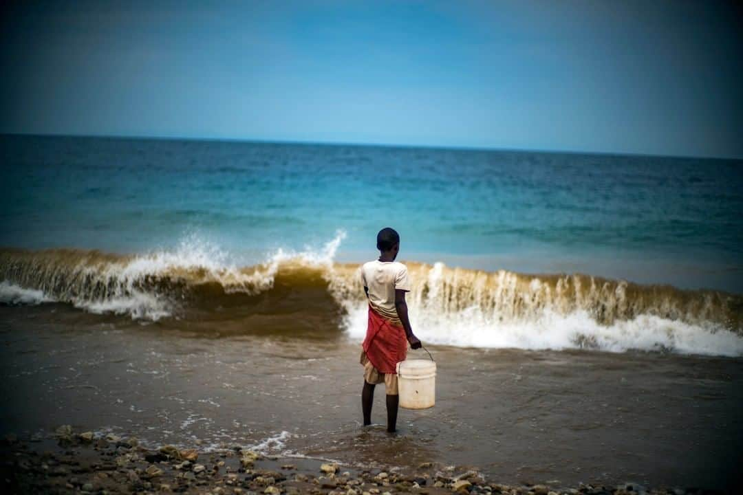 ナショナルジオグラフィックさんのインスタグラム写真 - (ナショナルジオグラフィックInstagram)「Photo by Michael Christopher Brown @michaelchristopherbrown | In the village of Mwamgongo, located just north of Gombe Stream National Park, Tanzania, a young man waits for a break in the waves in order to fetch drinking and cooking water from Lake Tanganyika. #tanzania #tanganyika」5月3日 9時34分 - natgeo