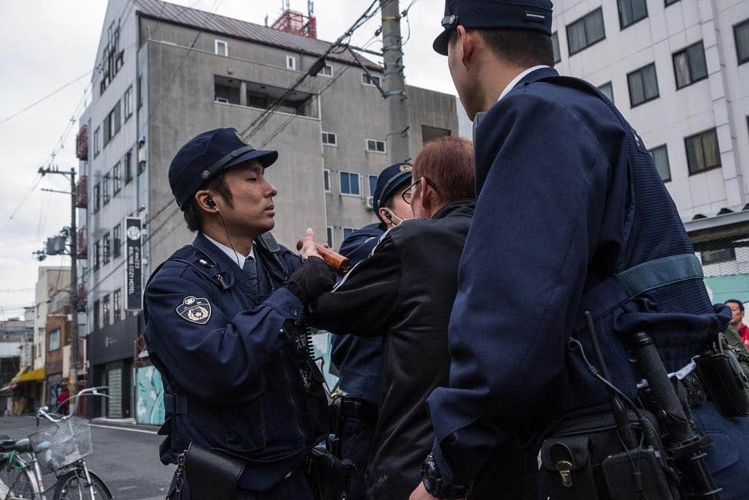 Q. Sakamakiさんのインスタグラム写真 - (Q. SakamakiInstagram)「Kamagasaki (Portrait) Series: captions— 1) Policemen subduing a man due to his street fighting. 2) Soup kitchen. 3) Kazuya Shimamoto, 66, hangs with pigeons, as he often loves to do so rather than humans. 4) Men playing a "shogi" game. 5) A monumental site for a man who died alone at a roadside, called as “ikidaore.” Such roadside death is a sort of common in Kamagasaki. 6) Street party tributing to their friend who died alone in the tiny apartment and were found days later. Kamagasaki, Osaka, shot in March, 2019. Kamagasaki is often called as the worst slum and/ or the most dangerous place in Japan. Yet many of them are so friendly and naive. So this time for many images, I have taken so at least somehow. However, it is true that many of Kamagasaki residents love the drinking so much and often tend to take the street fighting. Also there is an open secret — many residents, so many of them retirees, who live in poverty, are often exploited in their welfare system, even jobs, by middle-men, local government’s corruptions and/ or Yakuza, Japanese mafia. So, in addition to the friendly images, I will show Kamagasaki in the so-called typical reportage style as well. #kamagasaki #qs_kamagasaki #osaka #japan」4月29日 22時05分 - qsakamaki