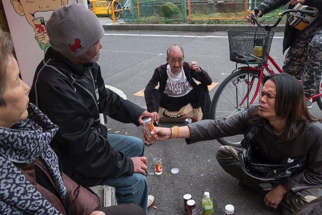 Q. Sakamakiさんのインスタグラム写真 - (Q. SakamakiInstagram)「Kamagasaki (Portrait) Series: captions— 1) Policemen subduing a man due to his street fighting. 2) Soup kitchen. 3) Kazuya Shimamoto, 66, hangs with pigeons, as he often loves to do so rather than humans. 4) Men playing a "shogi" game. 5) A monumental site for a man who died alone at a roadside, called as “ikidaore.” Such roadside death is a sort of common in Kamagasaki. 6) Street party tributing to their friend who died alone in the tiny apartment and were found days later. Kamagasaki, Osaka, shot in March, 2019. Kamagasaki is often called as the worst slum and/ or the most dangerous place in Japan. Yet many of them are so friendly and naive. So this time for many images, I have taken so at least somehow. However, it is true that many of Kamagasaki residents love the drinking so much and often tend to take the street fighting. Also there is an open secret — many residents, so many of them retirees, who live in poverty, are often exploited in their welfare system, even jobs, by middle-men, local government’s corruptions and/ or Yakuza, Japanese mafia. So, in addition to the friendly images, I will show Kamagasaki in the so-called typical reportage style as well. #kamagasaki #qs_kamagasaki #osaka #japan」4月29日 22時05分 - qsakamaki