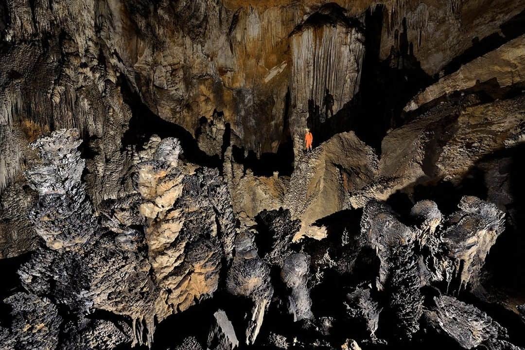National Geographic Travelさんのインスタグラム写真 - (National Geographic TravelInstagram)「Photo by Robbie Shone @shonephoto | Underground in China, a cave explorer is dwarfed by these incredible formations. They are heavily calcified stalagmites with a dry coating of a 'popcorn' like substance forming on a ledge overlooking a large passage in a cave called San Wang Dong in China's Wulong County. This very old high level fossil passage has long since lost the waters that helped build these delicate formations.」5月1日 3時57分 - natgeotravel