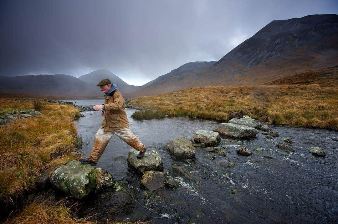 National Geographic Creativeさんのインスタグラム写真 - (National Geographic CreativeInstagram)「Photo by @jimrichardsonng | A hiker steps across rocks at the base of Beinn Shiantaidh, one of the famed Paps of Jura in Scotland. #Scotland #PapsOfJura #Adventure」4月9日 3時12分 - natgeointhefield