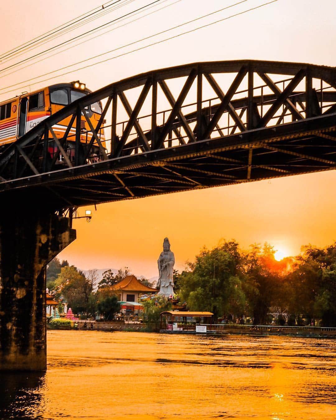 タイ国政府観光庁さんのインスタグラム写真 - (タイ国政府観光庁Instagram)「サワッディー・カー✨﻿ ﻿ 今週の #こんなタイ知らなかった は、カンチャナブリーの「クウェー川鉄橋」の１枚📷﻿ ﻿ オレンジ色に染まる夕暮れ時に、仏像を臨む場所から撮影された写真が美しいですね☺️﻿ ﻿ @hiko_pro さん、コップン・カー🙏﻿ ﻿ ・・・・・・・﻿ 今まで知らなかったタイの魅力を見つけたら、ハッシュタグ #こんなタイ知らなかった をつけて投稿して下さい！こちらでご紹介させて頂くことがあります。皆さんからの投稿をお待ちしています😊﻿ ﻿ #repost #タイ #カンチャナブリー #クウェー川鉄橋 #戦場にかける橋 #鉄道 #こんなタイ知らなかった #タイを知りつくす #タイ旅行 #ファインダー越しの私の世界 #写真好きな人と繋がりたい #絶景 #旅好きな人と繋がりたい #旅行好きな人と繋がりたい #ゆうやけこやけ部 #thailand #kanchanaburi #thebridgeoverriverkwai #amazingthailand #thailandtravel #thailandtrip #thai #thaistagram #lovethailand #localexperience #sunset﻿ ﻿」4月9日 18時45分 - amazingthailandjp