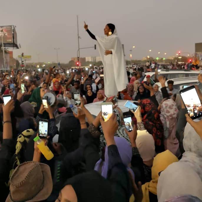 CNNさんのインスタグラム写真 - (CNNInstagram)「This image of a unidentified woman delivering an impassioned speech to protesters in #Sudan is going viral. The woman, in a long white dress and moon-shaped earrings, was speaking Monday in Khartoum, the nation’s capital, on the third day of a mass sit-in outside the presidential compound and army headquarters. “In the name of religion, they killed us,” the woman calls out, according to a translation. The crowd responds: “Revolution.” The protesters are calling for the resignation of President Omar al-Bashir, who has been in power for 30 years. (📸: Lana Haroun)」4月10日 0時00分 - cnn