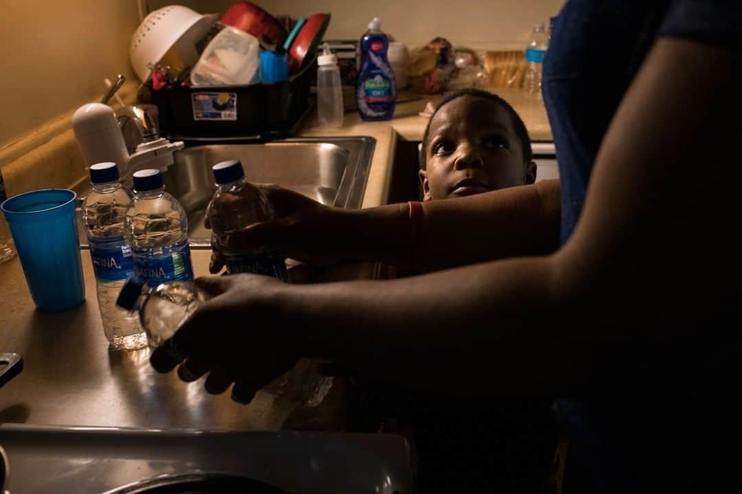 TIME Magazineさんのインスタグラム写真 - (TIME MagazineInstagram)「In Flint, residents still won't trust their taps. Five years ago this month, the city began using the corrosive #Flint River as its main source of water, which ate away the city's pipes and leached lead into the drinking #water of thousands of residents. Eighteen months later, the city reconnected to Detroit’s clean water supply after studies confirmed what parents had been telling officials: that lead from their taps was poisoning their families. Thousands of lead-tainted pipes have been replaced. More than a dozen officials connected to one of the worst health disasters in U.S. history are facing criminal charges. But for many residents, the crisis continues. Flint's families still stand in line for cases of bottled water. Parents are still fearful of lurking health problems. "Our kids are still sick and at risk," says Ariana Hawk. In this photo, Hawk, mother of Sincere, 6, starts warming bottled water to prepare a bath for her two younger children in April 2018. Sincere's fear of water never left him. "He talks about how it's poison," she says. "He doesn't trust water." Read more, and see more pictures, at the link in bio. Photograph by @brittanygreeson for TIME」4月12日 4時30分 - time