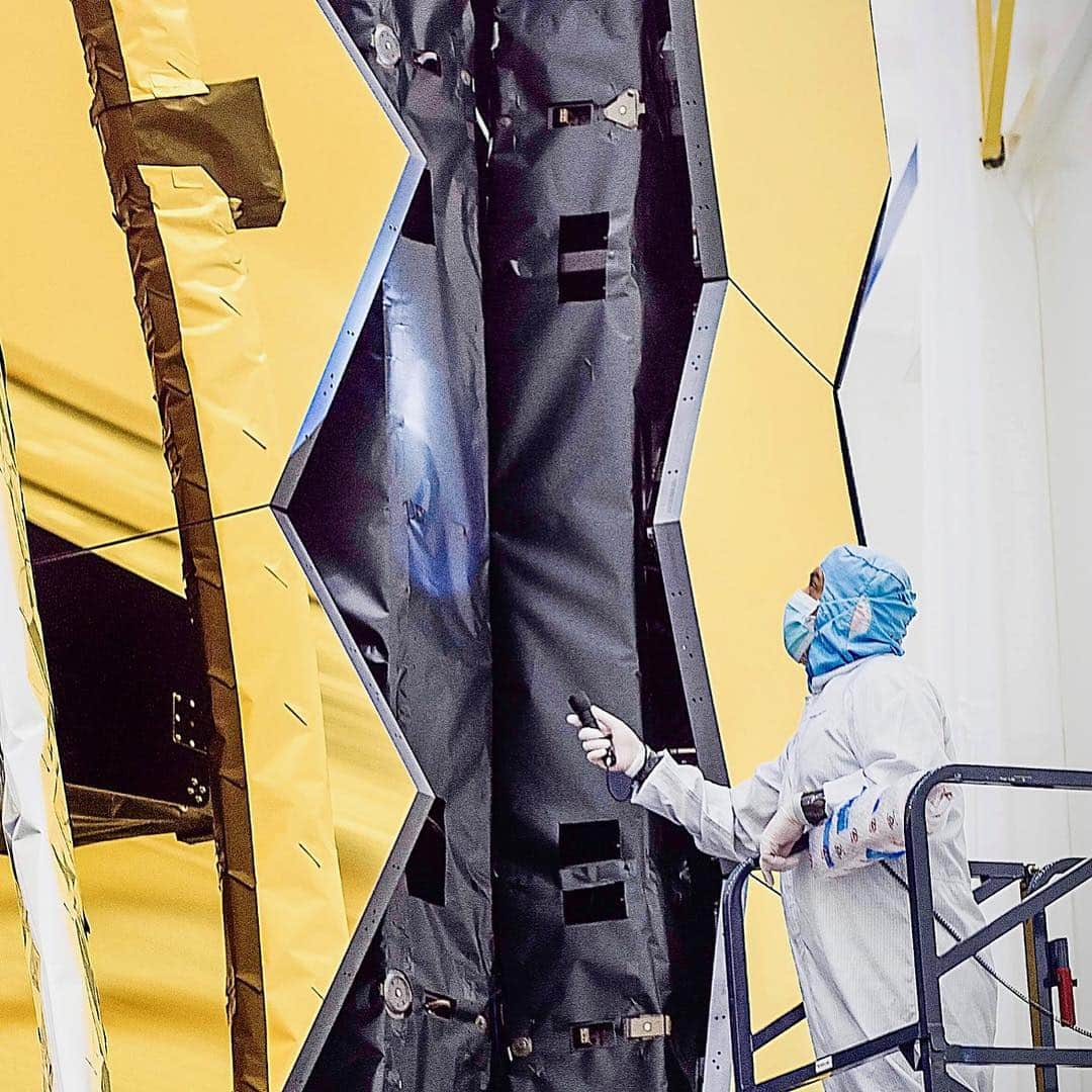 NASAさんのインスタグラム写真 - (NASAInstagram)「The @NASAWebb Telescope isn’t covered by a protective tube like @NASAHubble, instead technicians and engineers designed innovative shielding behind the primary mirrors — to keep out excess light.  Image 1: Northrop Grumman blanket technician Ann Meyer and Ball Aerospace optical engineer Larkin Carey inspect the protective barrier behind Webb’s primary mirror. This lightweight blanketing plays an important role on the observatory as it blocks undesirable light from reaching the telescope’s sensitive infrared sensors.  Image 2: To fit inside the Ariane 5 rocket that Webb will ride to space, some of its mirrors are designed to fold, and deploy to full size once in orbit. Shown here: technician Ricardo Pantoja performs a routine inspection of NASA Webb’s innovative blanketing along the connection point of its deployable primary mirror segments.  To observe objects in the distant cosmos, and to do science that’s never been done before, the Webb telescope’s scientific instruments need to be cooled down to a temperature so cold, it would freeze the oxygen in Earth’s atmosphere solid.  Intentionally chilling the telescope mirrors and instruments with innovative technologies and intelligent spacecraft design allows them to be far more sensitive to faint infrared light. Infrared can be described simply as heat, and if Webb’s components are cool, they are far more capable at observing faint heat signatures from the distant universe.  Image Credits: NASA/Chris Gunn  #jwst #space #telescope #webb」4月12日 23時05分 - nasagoddard