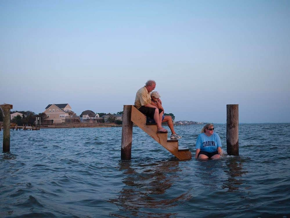 thephotosocietyさんのインスタグラム写真 - (thephotosocietyInstagram)「Photo by @davidalanharvey | We are often threatened by hurricanes here in the Outer Banks of N. Carolina. Statistics show us as target number one for these monster storms which originate in Africa before rolling into the Caribbean and then can veer up sweeping the entire eastern seaboard. Those of us who have chosen this barrier island, this sandbar, as home know we are taking our chances. These barrier islands are supposed to move with or without hurricanes or rising sea levels. My good neighbors Billy and Sandra Stinson were photographed by me for a NatGeo article on the outer banks. Ironically a summer storm cloud loomed in this published NatGeo Magazine picture,  yet none of us could imagine that just a few months later hurricane Irene would take away the Stinson summer home. Because I was already friends of the family from shooting and also a neighbor who had ridden out the storm, I was able to take the second image of the family grieving on the only piece of the house left after the soundside tidal wave took the house. Yet people want privacy in these moments. Diplomacy is a major part of people shooting. So I waded out in waist high water with a normal street camera moving very very slowly as not to disturb and hoping I did not step in a hole or trip or get hit by floating debris all of which were possible. Billy saw me out of the corner of his eye. If I had been any other news gatherer he would have been upset. Yet I knew I had to get this shot as part of the history of the outer banks and of course the Stinsons knew it too. Relationships matter.  To see the upcoming spring photo workshop at my home here in the Outer Banks see the link in my bio ( @davidalanharvey ) (May 19 - 25 / May 26 - Jun 1)」4月13日 3時31分 - thephotosociety