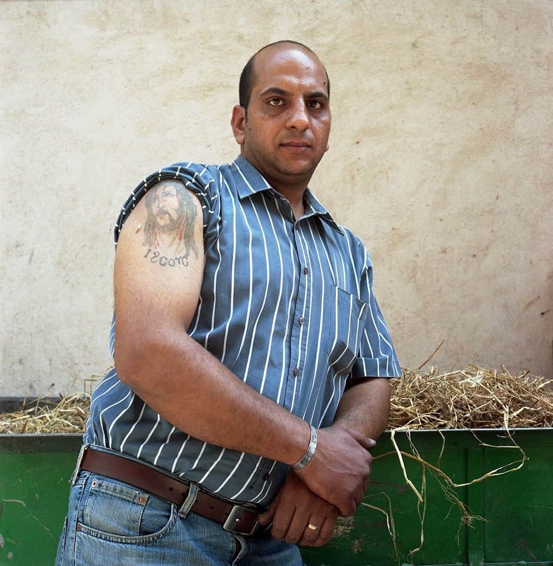 のインスタグラム：「Photo by @renaeffendiphoto | A Coptic Egyptian tattoo artist stands outside the Church of St. George (aka Mar Girgis) in Coptic Cairo. Copts continue the tradition of tattooing, which dates back to the era of pharaohs in ancient Egypt. A very common tattoo design is a small cross on the back of a wrist; tattooed crosses are the most common marks for the members of the Coptic community. Some other popular representations are the images of Jesus, the Virgin Mary, or Saint George. For more human interest stories around the world please #followme @renaeffendiphoto #coptic #cairo #egypt #culture #religion #tradition #tattoo #history」
