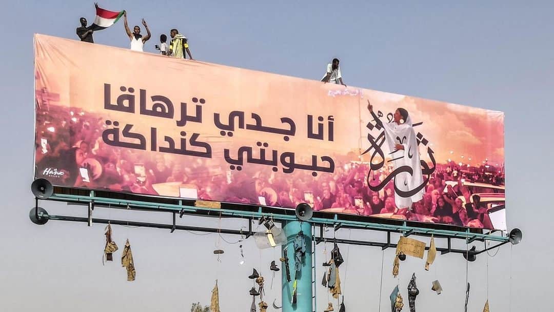 ルモンドさんのインスタグラム写真 - (ルモンドInstagram)「Khartoum, le 11 avril. Cette bannière a été hissée lors d’une manifestation précédant la destitution du président Omar Al-Bachir. Alaa Salah, l’étudiante devenue icône de la révolution soudanaise harangue la foule : « Mon grand-père est [le pharaon] Taharka, ma bien-aimée une [reine] kandaka ». Après trente ans de pouvoir, Omar Al-Bachir laisse un pays exsangue, sous la coupe des services de sécurité, qui ont accaparé les richesses et nourri les guerres. Les manifestants, à l’origine de son départ, ne veulent pas se laisser priver de leur révolution. - Photo : AFP (@AFPphoto) - #Sudan #SudanUprising #SudanRevolt」4月14日 17時34分 - lemondefr