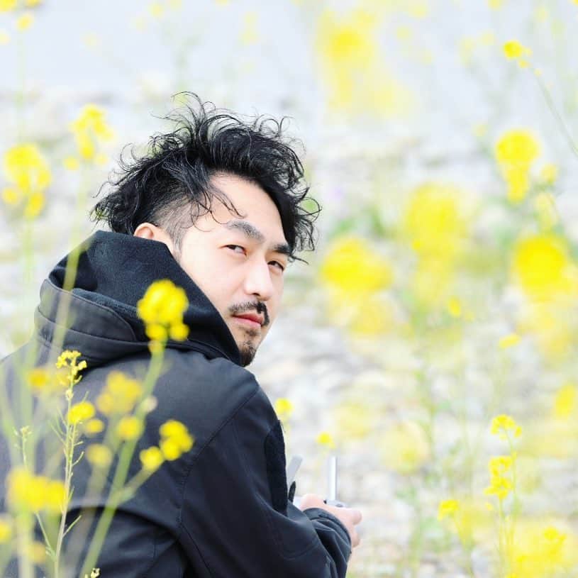 のインスタグラム：「He is practicing a drone. 「Let me see your smile ！Look at my camera.」 「.............」 .....Flowers are  always beautiful. . . . . . . . . . . #旦那 #husband #photooftheday #mylife #菜の花 #keep #cloudy #smile #nice」