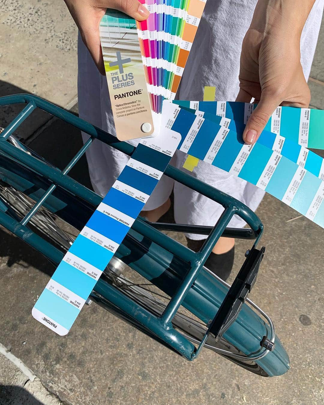 スコット・シューマンのインスタグラム：「What it takes to make a book! I’m finalizing elements of my upcoming book on India! On my way home from the gym this morning I saw a bike that was the color I want for the end pages of the book.  I ran home and marked a few potential colors in my Pantone books and ran back , with Jenny, to literally match it up to the bike!  I think we found a few good options! Hahaha you do what you gotta do!!」