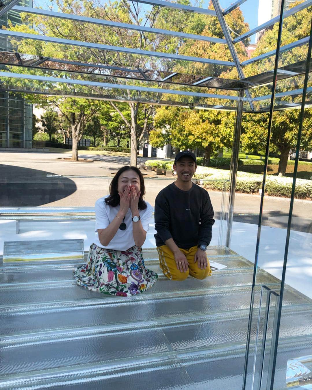 黒沢祐子さんのインスタグラム写真 - (黒沢祐子Instagram)「・ ・ ご縁あり明日から国立新美術館で2020年5月まで 公開の @tokujinyoshioka のガラスの茶室の お披露目会に行って参りました  4年くらい前に京都の蹴上将軍塚で見た時と 都会にワープしたそれは全く違う環境なんだけれど また六本木の中にもぴたっとはまる不思議なガラスの茶室  葉桜になりつつあるお庭で時折吹く風に桜が舞い散り ガラスの茶室をかすめる それもまた風情がありました  壇上に上がりご本人の設計秘話も伺え素晴らしき時間を 過ごしまさかのご厚意で茶室内に @yukiya.terai と 入らせていただきました ガラスの茶室に入った瞬間に時空が変わるのを感じ ガラスに正座しガラスに触れてパワーをいただきました  素晴らしい機会を頂いた @hideyaiida に心から感謝 明日から一般公開です 残念ながらステージには上がれませんが 素晴らしい建築なのでぜひ足を運んでみてください  #glassteahouse2020 #ガラスの茶室2020 #吉岡徳仁 #国立新美術館 #イケメン三人に感謝」4月16日 18時03分 - yukowedding