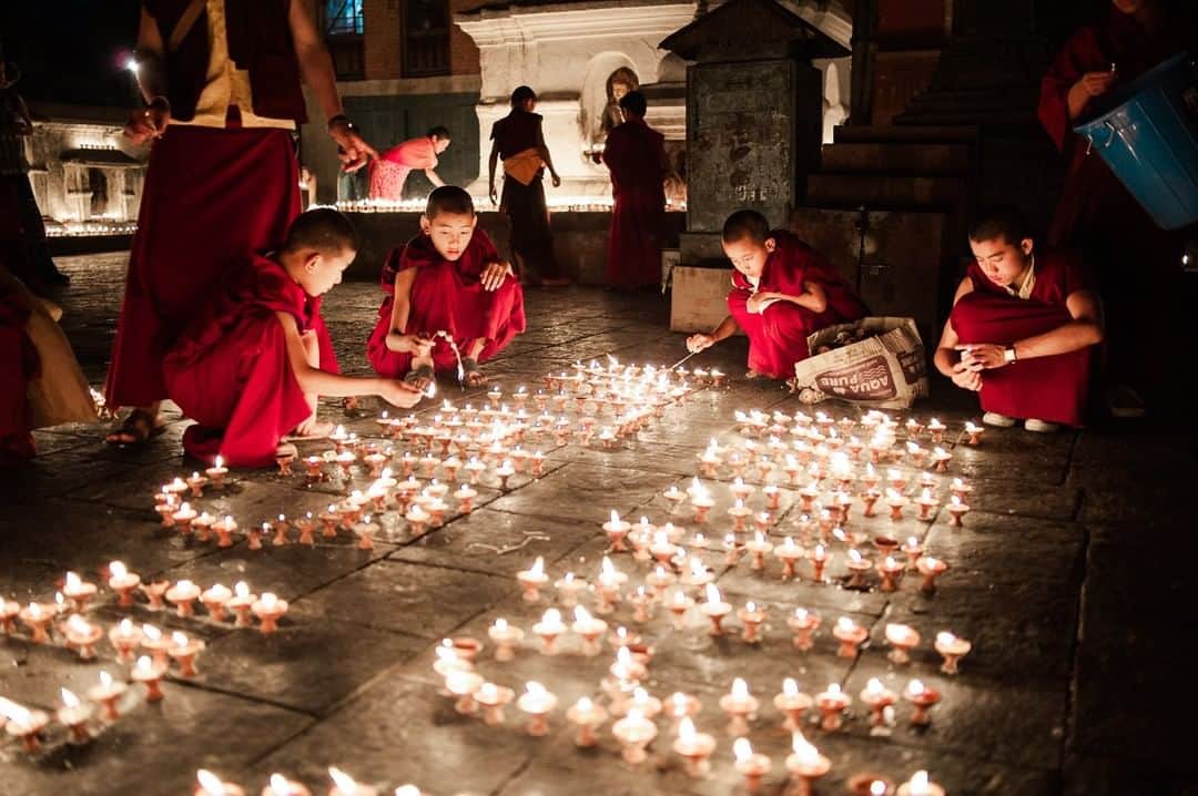 National Geographic Travelさんのインスタグラム写真 - (National Geographic TravelInstagram)「Photo by @MartinEdstrom | Lighting thousands of candles to celebrate the birthday of an elder, the young monks of Swayambhunath temple in Kathmandu literally light up the night. On these days, when the temple grounds come alive with fire, the blackouts that often hit the city below don't really matter as much. Since the two religions live side by side in Kathmandu, Hindus and Buddhists alike gather in celebration at this holy hill until the last of the candles burn out - or until the monsoon showers hit. #onassignment #natgeoimagecollection #kathmandu #worldheritage #temple」4月17日 13時04分 - natgeotravel