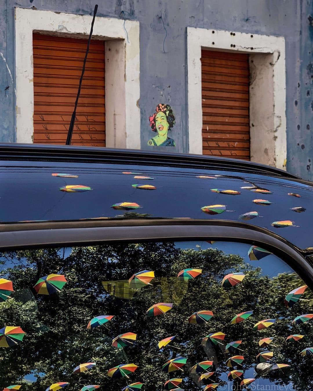 ジョン・スタンメイヤーさんのインスタグラム写真 - (ジョン・スタンメイヤーInstagram)「It wasn’t Frida Kahlo painted on the wall...Frida is beautifully everywhere here in Brazil. It was someone else, maybe laughing at me for imagining the car window was raining umbrellas on the streets of old Recife. Kind of an interesting thing about these umbrellas, the Sombrinha de Frevo, or the Little Umbrellas, they represent the Frevo (rhythm) that began 110 years ago, part of the richest connections of music, dance and culture found only here in Pernambuco State, northeast Brazil. ⠀⠀⠀⠀⠀⠀⠀⠀ Still in Recife, Brazil, for a project I am working on titled, #LifeAsLived, for @natgeolearning @cengagelearning @rippleeffectimages. These images will be used on children’s school books all around the world. - @natgeolearning @cengagelearning @rippleeffectimages @natgeo @natgeoimagecollection #brazil #recife #SombrinhadeFrevo #littleumbrellas #umbrellas #car #carwindow #reflection #graffiti」5月3日 20時29分 - johnstanmeyer