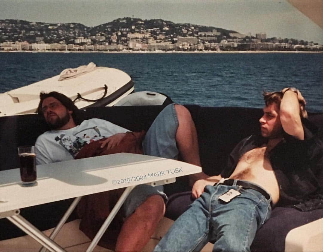 ケヴィン・スミスさんのインスタグラム写真 - (ケヴィン・スミスInstagram)「Throwback Thursday: Cannes 1994. I’m on the left and the stud on the right with the @festivaldecannes badge hung temptingly below his treasure trail is the better half of #smodcast, @grinchmovie director @samosier! Mister @marktuskflaneurfoto not only championed our first film #clerks, he also captured this casual (almost sexual) moment on the #pulpfiction yacht! Look at us: two crazy kids from the @vancouverfilmschool who made a movie with spit, glue, and credit cards, suddenly finding themselves at the center of the cinematic universe as their world cracks open! We were on the cusp of 24 and our dreams had kinda came true - and that was the moment Scott decided to tan his midriff. But 1994 Kev has no idea that, four years later in 1998 he’ll meet @jenschwalbach - or that he’ll become a Dad to @harleyquinnsmith five years later in 1999. In his mind, @jayandsilentbob are neither striking back nor rebooting - because when this moment was marked, the kid hiding his abs wants nothing more than to make #mallrats. This photo is 25 years old - but it feels like it happened last week. Life moves at the speed of Barry Allen. However, this @ww Ambassador would like to point out that he weighs less today than he did when this photo was taken. The kid in the picture gave me so much - the least I could do in return is to keep him alive as long as I can. (Follow @marktuskflaneurfoto for some killer indie film history pics! Mark was snapping pics the whole time he was helping the filmmakers you love launch their careers!) #KevinSmith #scottmosier #ww #wwambassador #cannesfilmfestival #cannes #marktusk  #throwbackthursday」4月19日 6時19分 - thatkevinsmith