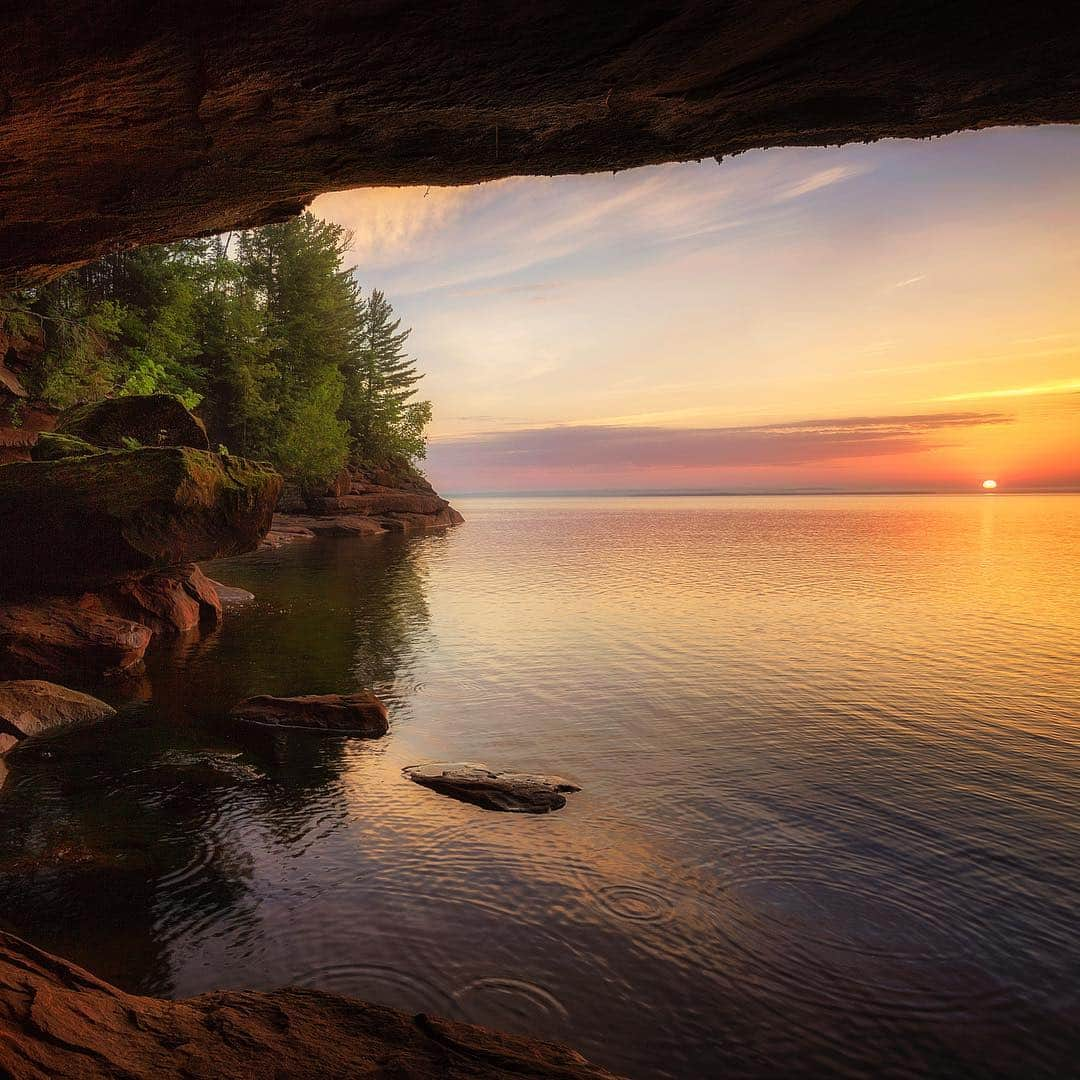 アメリカ内務省さんのインスタグラム写真 - (アメリカ内務省Instagram)「Peering through a sea cave at Apostle Islands National Lakeshore, you get a secret glimpse of the world. Located near the southwest tip of Lake Superior -- the largest and most pristine of the #GreatLakes -- #ApostleIslandsNationalLakeshore is comprised of 21 #islands and 13 miles of #Wisconsin shoreline. The colorful Precambrian sandstone has eroded into fascinating cliff formations and the park’s waters offer sailing, power #boating, sea #kayaking, #fishing and scuba diving. This photo captures a view from a little cove on Stockton Island that came down during powerful breaking waves in 2017. Photo by Michael DeWitt (@poordogphotography) (www.sharetheexperience.org). #usinterior #travel #findyourpark」4月20日 0時17分 - usinterior