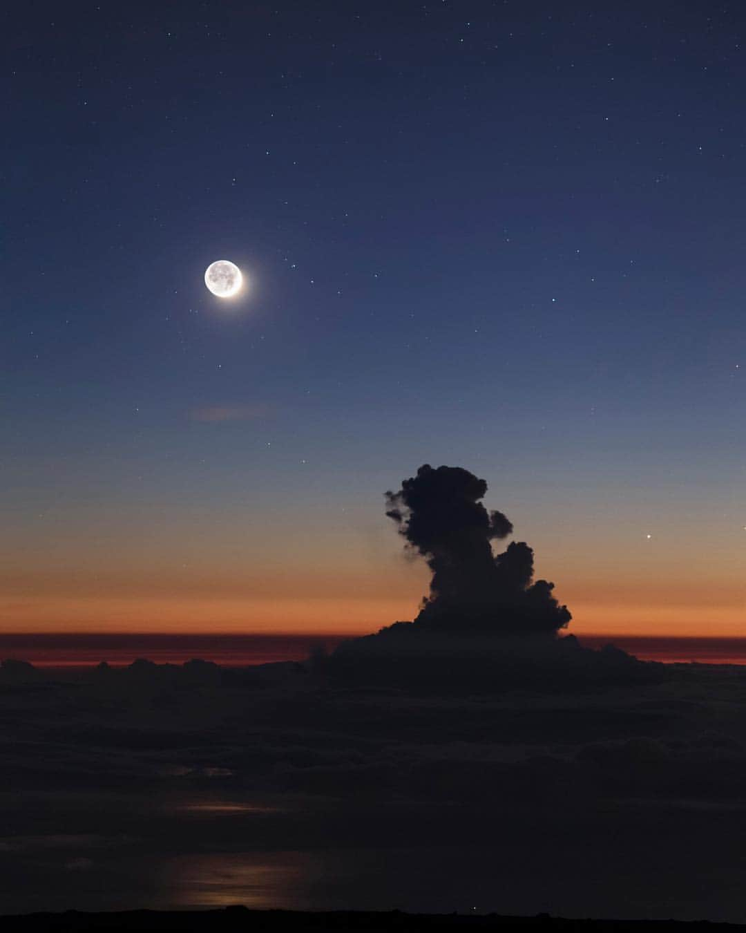 National Geographic Travelさんのインスタグラム写真 - (National Geographic TravelInstagram)「Photo by @babaktafreshi // Sponsored by @budweiserusa // On this evening at the 10,000-foot-high peak of Haleakala volcano in Maui, Hawaii, most visitors left after sunset. But the show continued under an emerging ocean of stars with the new moon reflecting on the Pacific waters as it was setting above a bizarre, towering cumulus cloud. The long-exposure image shows more than the thin crescent as it reveals the dark (night) side of the moon lit by the Earth. Easily visible to the naked eye, the subtle light is called earthshine or the Da Vinci Glow, first described by Leonardo da Vinci in the 16th century. // Introducing @BudweiserUSA #DiscoveryReserve, a limited-edition, American red lager brewed to celebrate the 50th anniversary of the Moon landing and the determination of the American spirit. #SpaceBeer」4月20日 4時03分 - natgeotravel