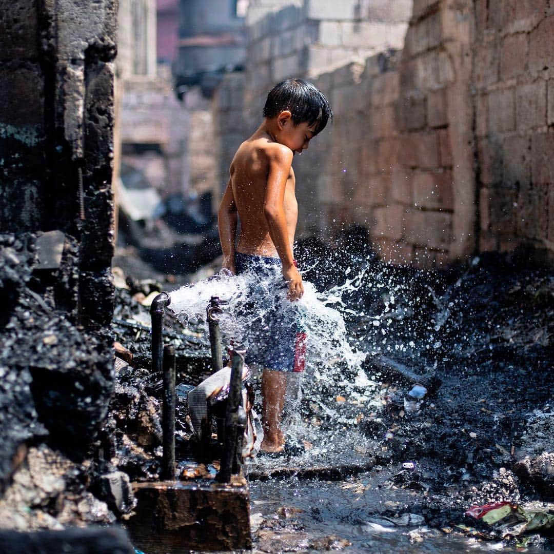 NBC Newsさんのインスタグラム写真 - (NBC NewsInstagram)「A boy enjoys water coming from a busted pipe that was damaged after a fire razed a slum area in Manila on Saturday. Hundreds of families were left homeless after the fire, according to officials. . 📷 @noelcelis / @afpphoto」4月21日 9時01分 - nbcnews