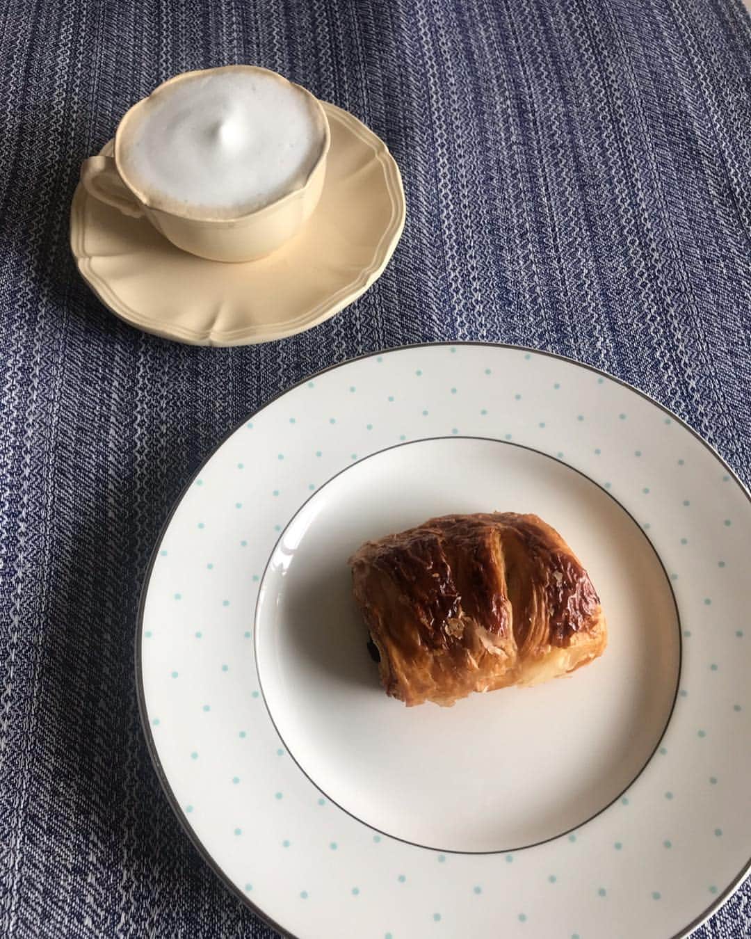 福田淳子さんのインスタグラム写真 - (福田淳子Instagram)「最近の朝ごはん。パン焼くのを始めたら楽しくて、それに伴いパン食べる機会が増えました。自家製のラムレーズンブレッドにクロテッドクリームをたっぷりと。クラストができるロッダのクロテッドクリーム大好きです。小さなキウイはベビーキウイ。皮ごと食べられます。キュート💚  濱田屋の豆パンはホットミルクと。たまに食べると「あー、やっぱりこれ好き」と思います。モチモチの生地に豆たっぷり。ほんのり塩味。好きなのを知ってる編集さんが差し入れしてくれました。  ホテルオークラのショコラフィユテ。母とランチ食べに行った時に帰りにシェフズガーデンカメリアで買いました。小ぶりでサクサクしてておいしい。温めたのでチョコもとろり。 この間バルミューダのリベイクモードでクロワッサン温めなおすと本当においしい、と聞いてバルミューダ熱がまた高まってきました。だってトーストの特集を担当した編集のひとたちがみんなバルミューダ買ってるんですよね。ぜんぜん違う、って。サクサクのクロワッサン食べながらどのくらい違うんだろうと思った朝でした。カフェ・オ・レと合わせてパリジェンヌ風味。  #今日の朝ごはん #ラムレーズンブレッド #ロッダクロテッドクリーム #濱田屋 #豆パン #シェフズガーデンカメリア  #ショコラフィユテ #バルミューダ」4月23日 9時58分 - junjunfukuda