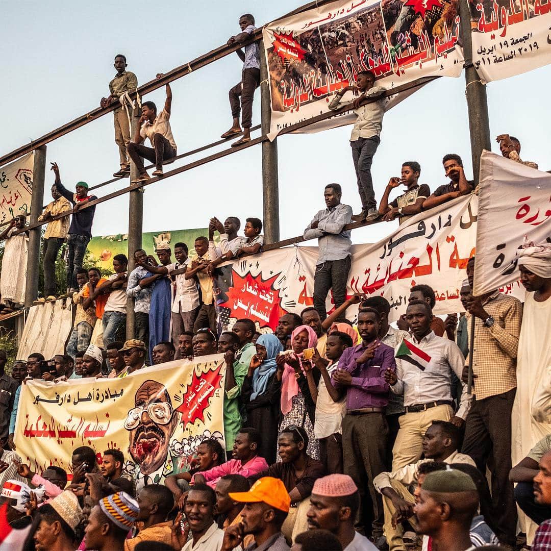 ニューヨーク・タイムズさんのインスタグラム写真 - (ニューヨーク・タイムズInstagram)「Civilian and military leaders are engaged in testy negotiations over the future of Sudan following the removal of its former president, Omar Hassan al-Bashir. Each side wants to take control, promising to undo the legacy of 3 decades of misrule under al-Bashir. Lt. Gen. Salah Abdelkhalig, Sudan’s Air Force chief, and other senior generals ousted al-Bashir in a bloodless coup, and al-Bashir is now in prison, under investigation for allegations of money-laundering and other financial crimes. Now tens of thousands of youthful protesters remain camped outside the military’s headquarters, refusing to leave until the military grants their demand for a swift transition to civilian rule. @bdentonphoto shot this photo of protesters in Khartoum, Sudan, last week as they listened to activists give speeches against al-Bashir’s regime. Visit the link in our profile to read more.」4月24日 8時00分 - nytimes