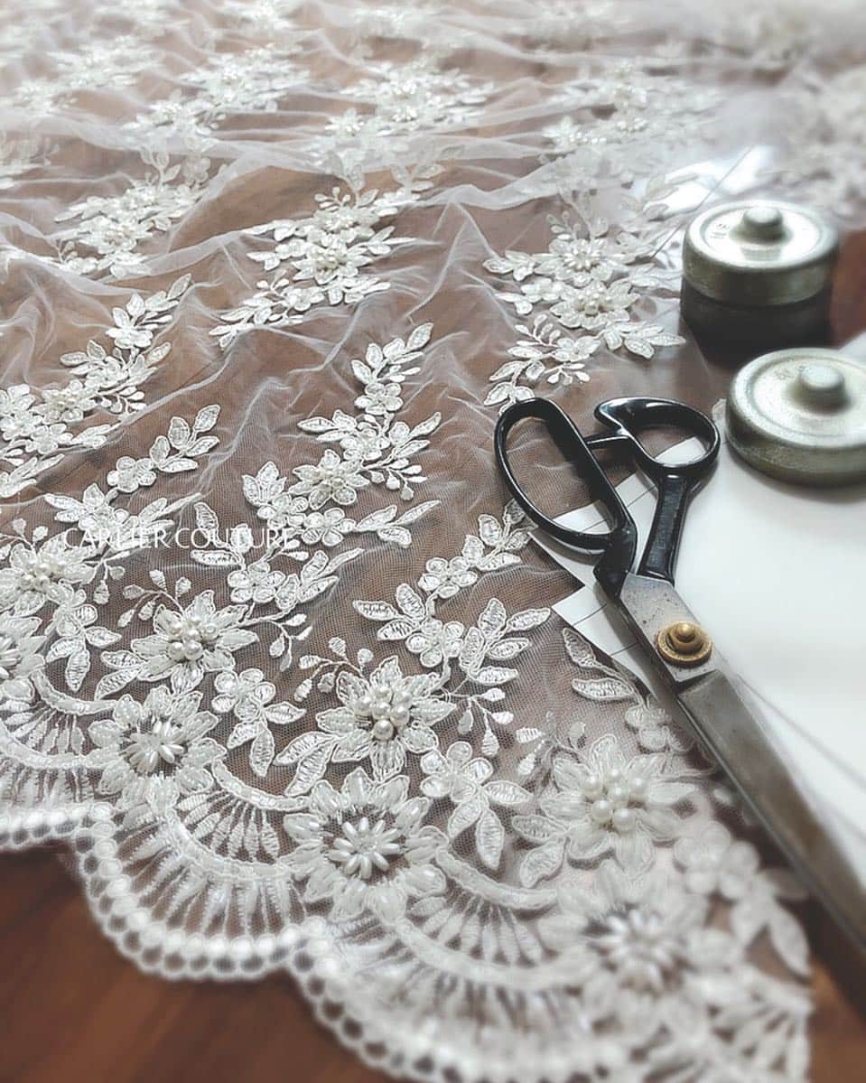 のインスタグラム：「. 【Carlier Couture diary】 cutting beaded lace . 最近の作業風景 レースを裁断する瞬間 . 今日は久しぶりにストーリーにも 上げてみましたが、ビーズレースの裁断は 少しだけ特殊。 . . こちらは花嫁さまがお選びになったレース 実際には別のスカラレースと 組み合わせて使用します。 . 前撮りにもご使用いただくとのこと どんな風になるか楽しみ…🌱 . . .」