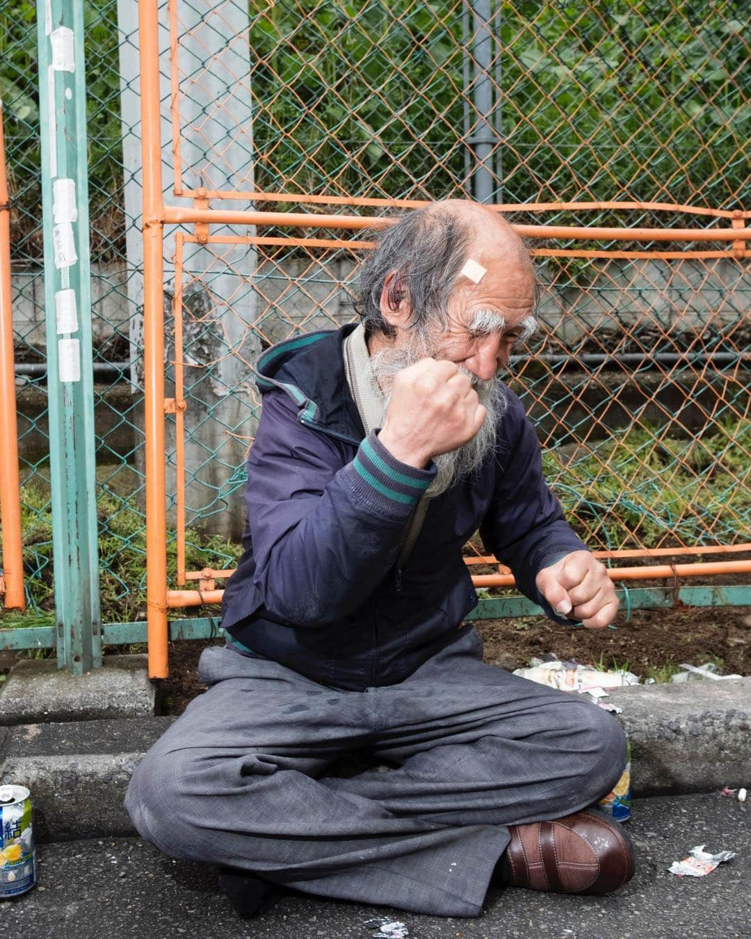 Q. Sakamakiさんのインスタグラム写真 - (Q. SakamakiInstagram)「Hige Jijii — literally an Old Man with Beard for his nickname, or Natsumi Sasai on the real name, takes instinctively the fighting-pose momentally after he got the recovery from the fainted condition due to the street fighting. Kamagasaki, Osaka, March in 2019. Kamagasaki is often called as the worst slum and/ or the most dangerous place in Japan. Yet many of them are so friendly and naive. So this time for many images, I have taken so at least somehow. However, it is true that many of Kamagasaki residents love the drinking so much and often tend to take the street fighting. Also there is an open secret — many residents, so many of them retirees, who live in poverty, are often exploited in their welfare system, even jobs, by middle-men, local government’s corruptions and/ or Yakuza, Japanese mafia. So, in addition to the friendly images, I will show Kamagasaki in the so-called typical reportage style as well. #kamagasaki #qs_kamagasaki #osaka #japan」4月26日 21時59分 - qsakamaki