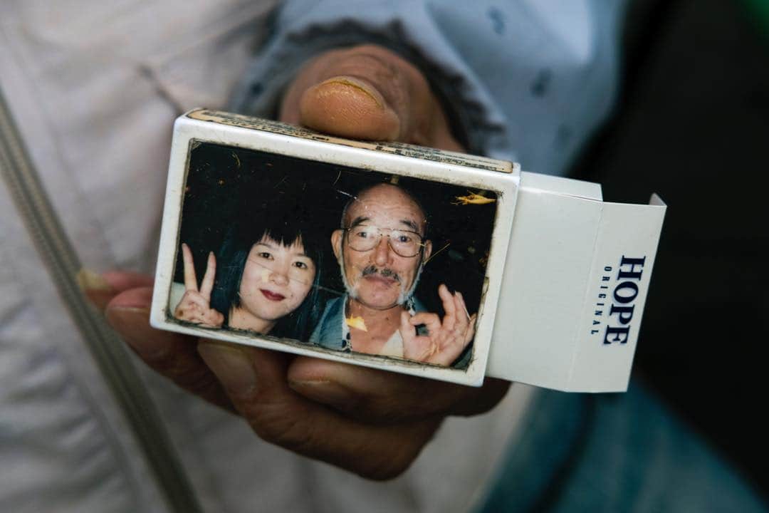 Q. Sakamakiさんのインスタグラム写真 - (Q. SakamakiInstagram)「Kamagasaki Portrait Series: Noriyuki, 74 year old Kamagasaki resident, holds a memoir photo attached-pack of cigaret. He came to the community, escaping from other part of Osaka, as he had a problem. Now he has been living in Kamagasaki for 7 years. Kamagasaki, Osaka, March, 2019. Kamagasaki is often called as the worst slum and/ or the most dangerous place in Japan. Yet many of them are so friendly and naive. So this time for many images, I have taken so at least somehow. However, it is true that many of Kamagasaki residents love the drinking so much and often tend to take the street fighting. Also there is an open secret — many residents, so many of them retirees, who live in poverty, are often exploited in their welfare system, even jobs, by middle-men, local government’s corruptions and/ or Yakuza, Japanese mafia. So, in addition to the friendly images, I will show Kamagasaki in the so-called typical reportage style as well. #kamagasaki #qs_kamagasaki #osaka #japan」4月27日 22時33分 - qsakamaki