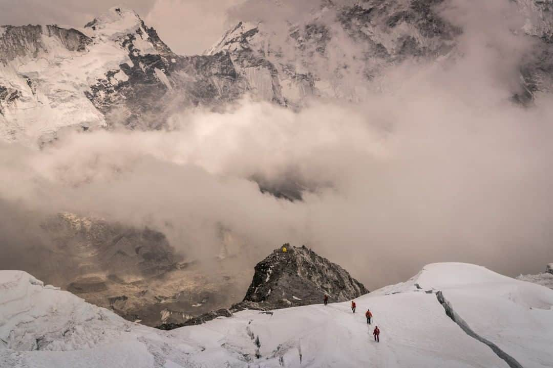 National Geographic Travelさんのインスタグラム写真 - (National Geographic TravelInstagram)「Photo by @coryrichards | Mount Everest is both a travel destination as much as it’s a proving ground for serious alpinists. Seen here is my lone yellow tent mid-frame while my partner and I acclimatized on Everest’s nearby mountain, Island Peak. Traveling mountaineers can be seen along side the deep crevasse to their right. Dangers like these are present for the traveler and the seasoned alpinists alike. #followme @coryrichards to see real-time footage of Himalayan #travel #culture and #mountains as I am attempting to #climb new route on the North East face of #everest.」5月24日 19時08分 - natgeotravel