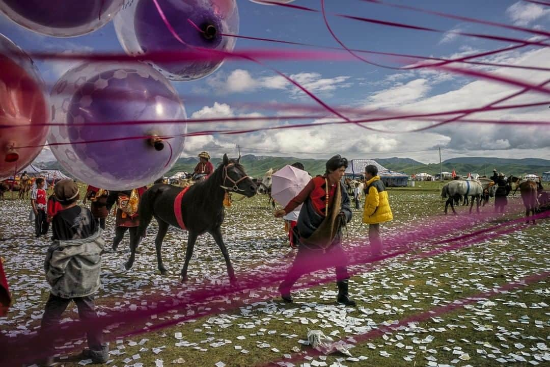 ナショナルジオグラフィックさんのインスタグラム写真 - (ナショナルジオグラフィックInstagram)「Photo by Fritz Hoffmann @fritzphotos | The Tibetan horse racing season is approaching. At the Maqu Gesar races in the Gannan Tibetan prefecture in Gansu, China, a nomad leads a horse across grass fields littered with prayer notes on the way to the race track. To send the prayer notes to higher places, the notes are placed in helium filled balloons, which are let go to rise to the heavens. This week I'm posting pictures from races past, longing to be there myself. Please check out my feed at @fritzphotos #FritzHoffmann #MaquHorseRaces #MaquGrasslands #TibetanHorseFestival #Gannan」5月24日 15時39分 - natgeo