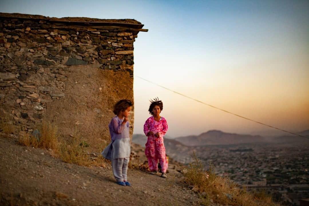 のインスタグラム：「Photo by Michael Christopher Brown @michaelchristopherbrown | Young girls walk in a light breeze at sunset outside their home overlooking the city of Kabul, Afghanistan.」