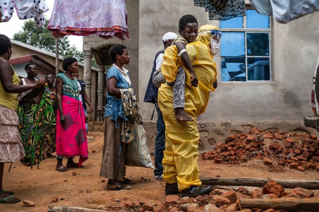 のインスタグラム：「Photo by @nicholesobecki | A health worker carries Kakule Kavendivwa, 14, to a waiting ambulance in Beni, Democratic Republic of Congo. The day before Kakule's sisters had taken him to a nearby health center, but fled when the team encouraged them to go to an Ebola treatment center. The health center alerted the World Health Organization who found the family. After several hours of talking with community outreach workers, they allowed an ambulance to take him for treatment. “People need to have a chance to talk,” Zoe Kyavaghendi, a risk communication officer told me as we waited for Kakule's sisters to consider their options. “You can’t force them right away, you need to give them a chance to express their fears, and then to explain afterwards.” To learn more about the ongoing Ebola outbreak — already the second largest in history, and the first in an active war zone — take a look at our story “Life amid an Ebola outbreak: Combating mistrust—and saving lives.” @nicholesobecki #ebola #drc #health #epidemic」