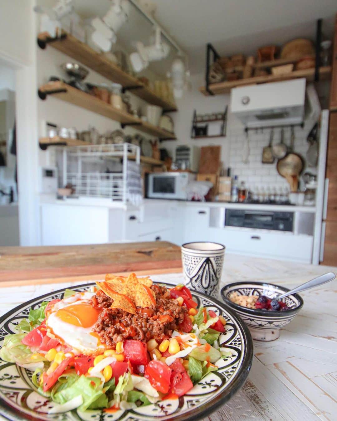 のインスタグラム：「お休みの日は簡単ごちそうタコライス。 . . ※レシピ .  合挽肉を玉ねぎみじんと合わせて炒め、ケチャップとソースで味付けして冷ましておく . サイコロ状にカットしたトマトとコーンの缶詰を、タバスコ（お好み量）とブラックペッパーでマリネ . ごはんにレタスをたっぷり . トマトのマリネたっぷり . ピザ用チーズをまぶして . さましておいたミートを乗っけ . 半熟目玉焼き乗せて . お好みで、サルサソースやマヨネーズなどかけて完成 . びっくりするくらい美味しいです😆 . タコスミートは作って冷凍しておいて、何にもない時にはパスタにかけてミートソースにしたり、ご飯にかけてチーズを乗せてオーブンで焼けば、ミートドリアと万能なので、冷凍庫には常にストックしてあります♬ . 使い回しが大好きのですฅ^._.^ฅ」
