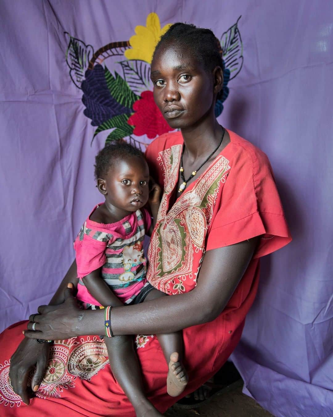 ナショナルジオグラフィックさんのインスタグラム写真 - (ナショナルジオグラフィックInstagram)「Photo by Nora Lorek @noralorek | Not long after Angelina Nyakum came to Uganda in the summer of 2016, her husband was killed in South Sudan. He had been walking past a street fight. In Bidibidi refugee camp, 27-year-old Angelina is left to care for their children. "They don't believe me that their father is dead," she says. "They still ask to call him all the time." What began as a @natgeo assignment is now the @milayaproject, a nonprofit we just launched on Kickstarter to connect customers with South Sudanese women making hand-embroidered pillowcases, bedspreads, and wall hangings, like those seen in the background. The civil war in South Sudan has displaced two million people. When refugees arrived to Uganda they carried their only possessions wrapped in milayas, embroidered sheets passed down for generations. Today in Bidibidi, the second largest refugee camp in the world, milayas are being sewn but there are few customers. Through the Milaya Project these women will be able to sell their art and transform their collectives into self-sufficient businesses. Follow @milayaproject for more information on how to support these women.」5月26日 15時39分 - natgeo