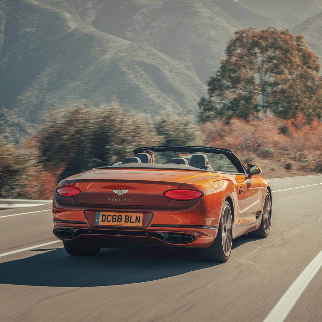 のインスタグラム：「Elliptical lamps shine from within individual polished bezels at the rear of the #ContinentalGTC. Exterior paint: Orange Flame. Link in bio.  Continental GT Convertible WLTP drive cycle: fuel consumption, mpg (l/100km) - Combined 20.2 (14.0). Combined CO2 – 317 g/km.」