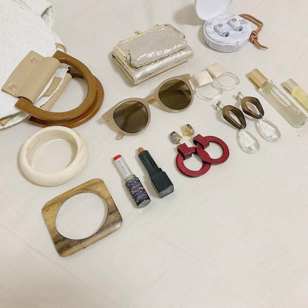 mina hinokuchiのインスタグラム：「. #カバンの中身 🌻 質問コーナーで多いカバンの中身、最近の持ち物はこんな感じです☀︎ . お洋服を新作買って合わせることも多いのでアクセ2・3個と、お直し用のリップはお洋服に合わせてorお気に入りの物を2つ以上持ち歩いています🌿 香水とネイルオイルとイヤホンは常に持ち歩いてる必需品🎧 . 最近のお気に入りリップはCelvoke 09番とshuのキツネコラボのOR 568です💄 アクセ・バック・お財布・サングラスはほぼChicoです♡ . #whoswhochico #meowpopupshop #ukanailoil #theperfumeoilfactory #shuuemura #celvoke #sudio」
