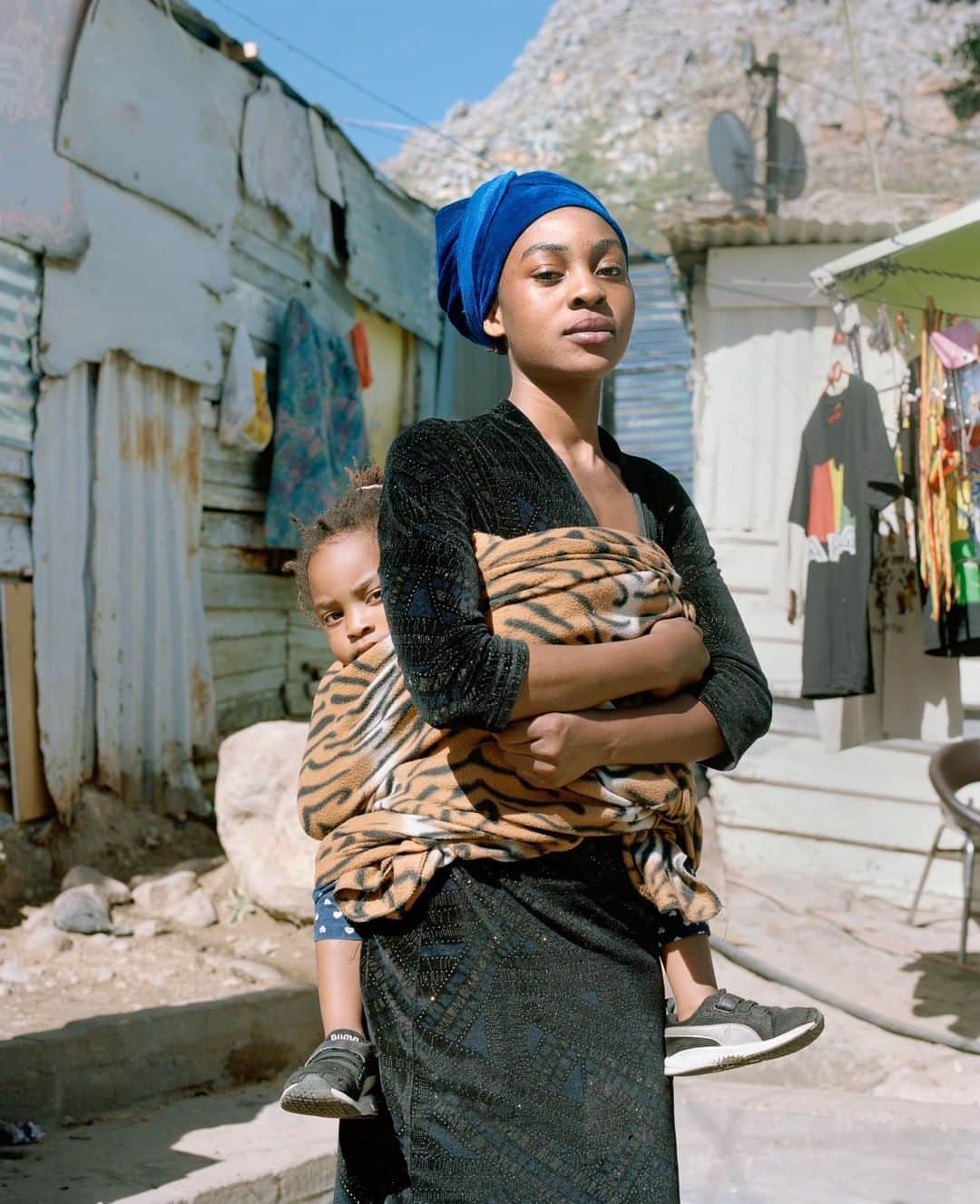 TIME Magazineさんのインスタグラム写真 - (TIME MagazineInstagram)「Natasha Manda, 20, and her daughter, Grace. Manda has been living in the Imizamo Yethu settlement for three years. Even for the Western Cape, a province known for its stunning vistas, the view from the settlement is extraordinary. To one side is a fishing village that has gentrified into quaint cafés and handicraft shops; on the other are mansions, horse paddocks and a prestigious private school. The view of Imizamo Yethu from the suburb below, Hout Bay, is also extraordinary, if for different reasons. This ramshackle settlement is made up of small brick houses, corrugated-aluminum shacks and lean-tos constructed from old shipping pallets. More than 6,000 black families live in this area, which is about the size of a suburban American shopping mall. Hout Bay, about 50 times larger and mostly white, has roughly the same number of residents. It’s been 25 years since #SouthAfrica’s first multi-racial democratic elections were supposed to bring an end to the institutionalized racial segregation of the apartheid regime. But little has changed, says Kenny Tokwe, a community organizer who has been living in Imizamo Yethu for nearly three decades. “South Africa is still a country of two nations: the rich whites”—he points down the hill—“and the poor blacks.” With a chuckle, he points at himself, an educated black man who spent his youth campaigning for equal rights for South African blacks only to find himself, at 58, fighting for them to have basic standards of living. Read more at the link in bio. Photograph by @sarahnankin for TIME」5月4日 22時15分 - time
