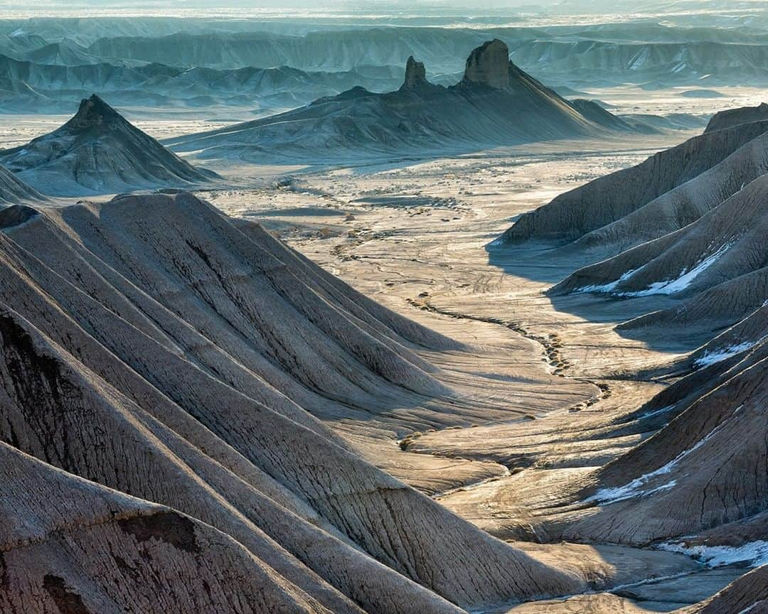 National Geographic Travelさんのインスタグラム写真 - (National Geographic TravelInstagram)「Photo @stephen_matera | Fleeting winter snow lingers in the shadows on the lower flanks of North Caineville Mesa near Caineville, Utah. Nearby and just outside of the boundary of Capitol Reef National Park is an area of exposed bentonite, which is a colorful remnant of fine volcanic ash and silt deposited during the Jurassic period 140 million years ago. Follow me @stephen_matera for more images like this from Utah and around the world. #desert #erosion #winter #snow」5月5日 13時01分 - natgeotravel